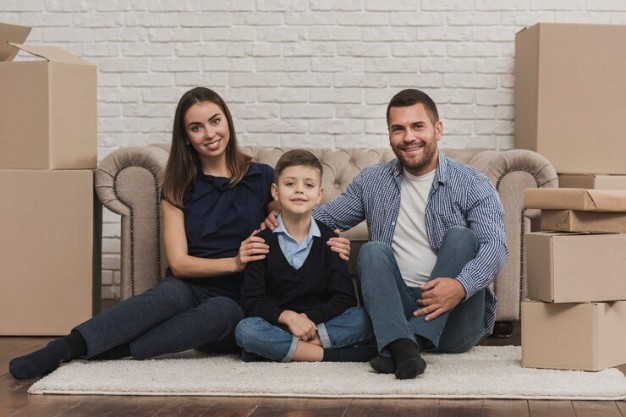 A family standing in front of their new home, looking happy and excited